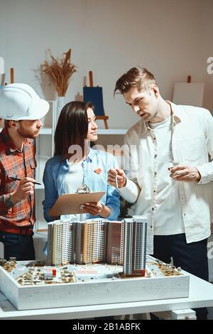 Das junge kreative Team, das Brainstorming-Sitzung y hat, ist mit kreativen Lösungen und produktiven Aufgaben, vertikalen Aufnahmen, zufrieden. Nahaufnahme Stockfoto