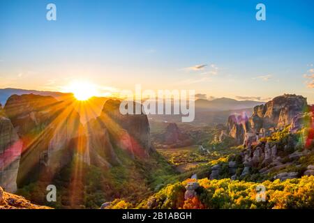 Griechenland. Sommeruntergang über einem griechischen Felsklosterei in Meteora (in der Nähe von Kalambaka) und Sonnenstrahlen Stockfoto