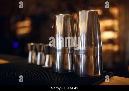 Metallkaffee zum Kochen von Uttensilen, Nahaufnahme. Verschwommener Hintergrund. Kaffeemaschine nützliche Werkzeuge Tassen, Brille, wählen Sie nur die besten Tassen aus Stockfoto
