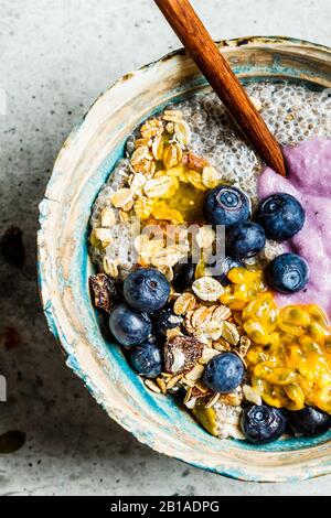 Chia Pudding-Schüssel mit Blaubeeren, Passionsfrucht, Granola und Joghurt. Gesundes Frühstückskonzept. Stockfoto