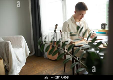 Kreativer seriöser Sänger, Musiker, der Lieder schreibt, der Mann entwickelt künstlerische Fähigkeiten. Nahansicht Foto. Online-Ausbildung Stockfoto