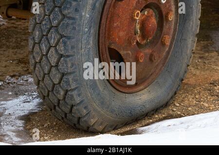 Alter gerissener Reifen an einer großen Maschine. Stockfoto