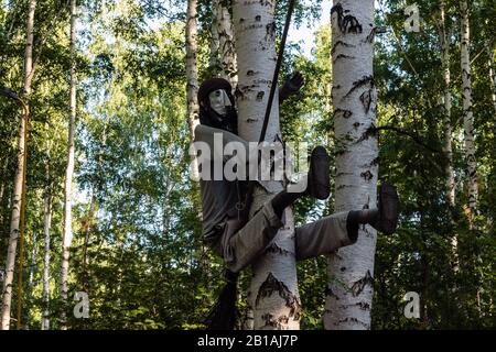 Die Figur des russischen Märchens Baba Yaga, das einen Bromstab reitet, sitzt auf einem Baum. Stockfoto