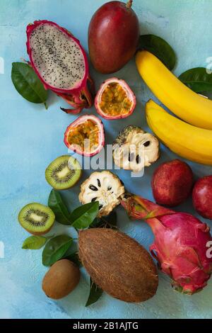 Fruchthintergrund. Verschiedene reife, saftige Exotische asiatische Sommerfrüchte auf blauem Steingrund. Flacher Laienhintergrund in der Draufsicht. Stockfoto