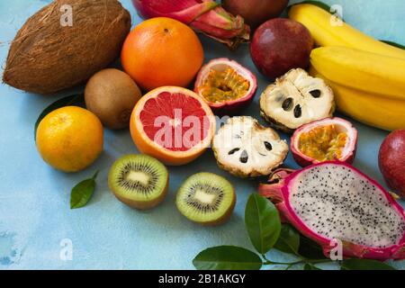 Fruchthintergrund. Verschiedene reife, saftige Exotische asiatische Sommerfrüchte auf blauem Steingrund. Kopierbereich. Stockfoto