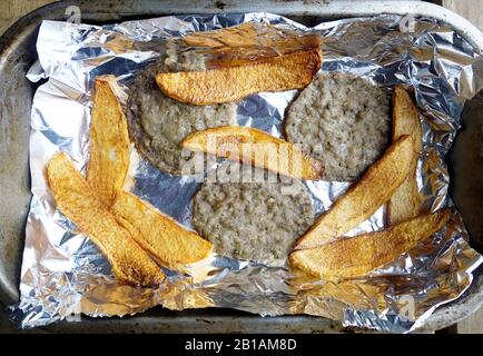 Griechische Küche. Frisch gebackene Rindfleisch-Burger und Chips Stockfoto