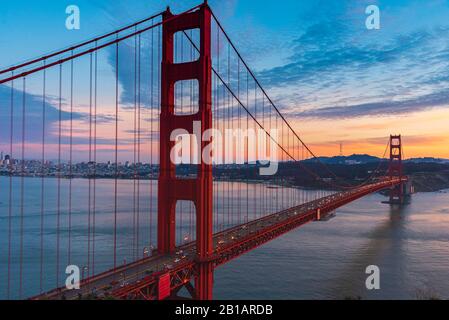 Blick auf die Golden Gate Bridge bei Nacht mit Lichtreflexionen im Wasser Stockfoto