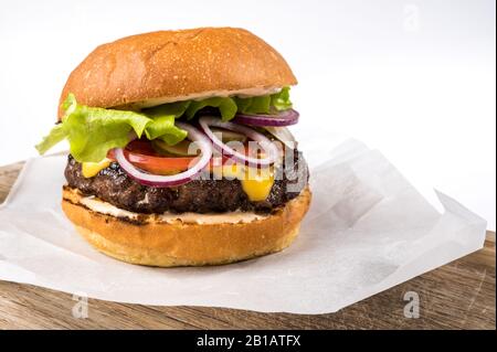 Leckerer hausgemachter Hamburger mit Salat, Tomate und Käse. Nahaufnahme des Fotos Stockfoto