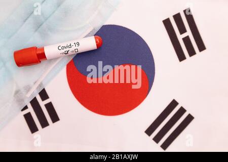 Das Konzept des Romans Coronavirus verbreitete sich von China nach Südkorea - 2019-nCoV oder Covid-19 Krankheit-Positivtest auf südkoreanischer Flagge, der mit Blut gezeigt wurde Stockfoto