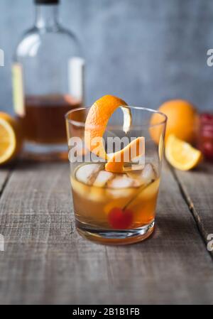 Nahaufnahme eines altmodischen Cocktails mit Zutaten auf einem Holztisch. Stockfoto