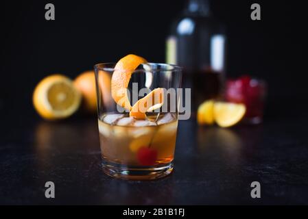 Altmodischer Cocktail mit Zutaten auf schwarzem Hintergrund. Stockfoto