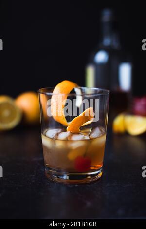 Altmodischer Cocktail mit Zutaten auf schwarzem Hintergrund. Stockfoto