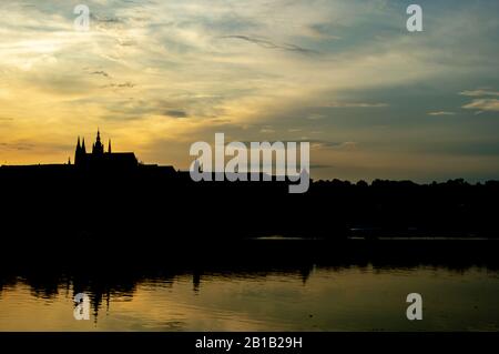 Landschaft über Der Moldau in Prag, Tschechien bei Sonnenuntergang mit Prager Burg am Horizont Stockfoto
