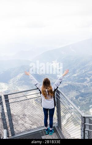 Das junge Mädchen genießt den Blick auf die Alpen von der Aussichtsplattform Stockfoto