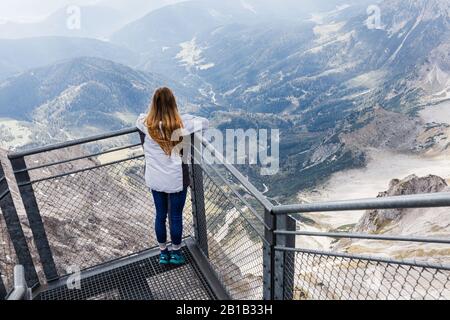 Das junge Mädchen genießt den Blick auf die Alpen von der Aussichtsplattform Stockfoto