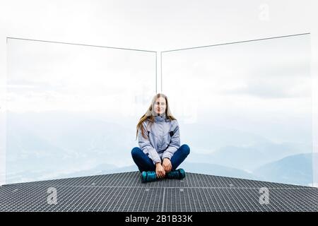 Das junge Mädchen genießt den Blick auf die Alpen von der Aussichtsplattform Stockfoto