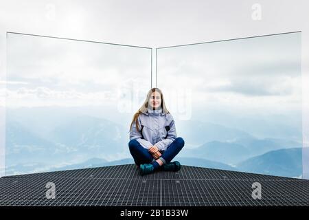 Das junge Mädchen genießt den Blick auf die Alpen von der Aussichtsplattform Stockfoto