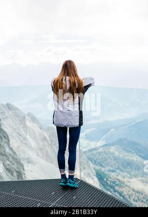 Das junge Mädchen genießt den Blick auf die Alpen von der Aussichtsplattform Stockfoto