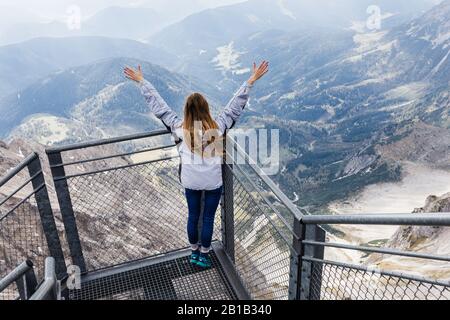 Das junge Mädchen genießt den Blick auf die Alpen von der Aussichtsplattform Stockfoto