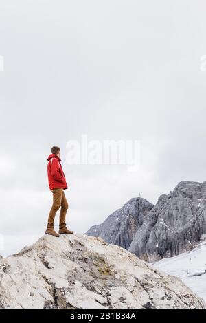 Der junge Millennials genießt den Blick auf die Alpen, die auf dem Gletscher stehen Stockfoto