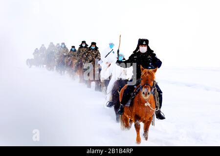 Chinesische Polizisten, Grenzbeamte und medizinische Arbeiter fahren Pferde im Schnee, um lokale Familien zur Prävention des neuen Coronavirus und der Pneumonie im Landkreis Fuyun, Präfektur Altay, im Nordwesten Chinas Xinjiang Uygur am 19. Februar 2020 zu besuchen. (Foto von RAN / Costfoto / Sipa USA) Stockfoto