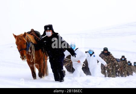 Chinesische Polizisten, Grenzbeamte und medizinische Arbeiter laufen mit Pferden im Schnee, um lokale Familien zur Prävention des neuen Coronavirus und der Pneumonie im Landkreis Fuyun, Präfektur Altay, im Nordwesten Chinas Xinjiang Uygur am 19. Februar 2020 zu besuchen. (Foto von RAN / Costfoto / Sipa USA) Stockfoto