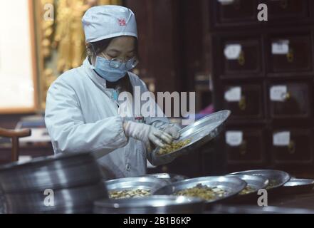 Ein chinesischer Mitarbeiter verzichtet am 21. Februar 2020 auf die traditionelle chinesische Pflanzenheilkunde (TCM) zur Vorbeugung des neuen Coronavirus und der Pneumonie in einer Drogerie in Hangzhou City, der ostchinesischen Provinz Zhejiang. (Foto von Long Wei / Costfoto / Sipa USA) Stockfoto