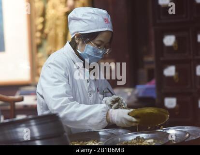 Ein chinesischer Mitarbeiter verzichtet am 21. Februar 2020 auf die traditionelle chinesische Pflanzenheilkunde (TCM) zur Vorbeugung des neuen Coronavirus und der Pneumonie in einer Drogerie in Hangzhou City, der ostchinesischen Provinz Zhejiang. (Foto von Long Wei / Costfoto / Sipa USA) Stockfoto