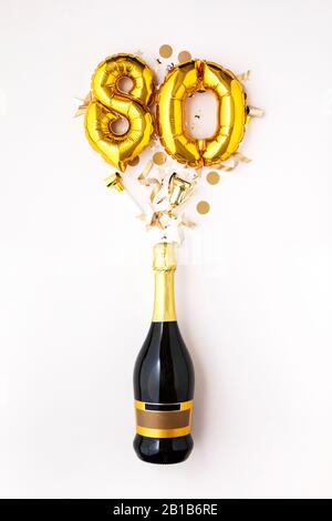 Happy 80th Anniversary Party. Champagner Flasche mit gold Ballon Nummer. Stockfoto