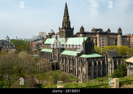 Glasgow Cathedral (St. Mungo's) im Stadtzentrum von Glasgow, wie sie von der Necropolis an einem sonnigen Tag mit Glasgow Royal Infirmary im Hintergrund zu sehen ist. Stockfoto