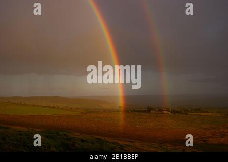 Blick Vom Hadrianswall eines doppelten Regenbogens während eines Sturms, Northumberland, England, Großbritannien. Stockfoto