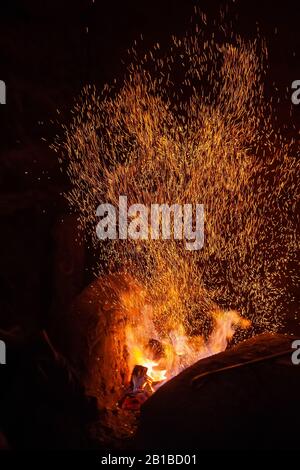 Schmiede Feuer Flamme Tipps mit Funken closeup auf dunklem Hintergrund Stockfoto