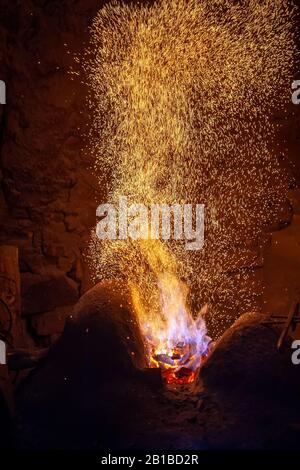 Schmiede Feuer Flamme Tipps mit Funken closeup auf dunklem Hintergrund Stockfoto