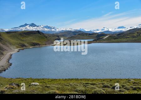 Schotterstraße im Nationalpark Torres del Paine mit Bergen und Seen, patagonien, Chile Stockfoto