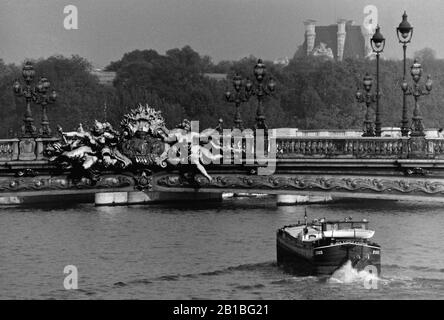 AJAXNETPHOTO. SEPTEMBER 1971.PARIS, FRANKREICH. - UNTER DEN BRÜCKEN VON - EINE FREYCINET PENICHE FÜHRT SÜDLICH UNTER DER ZARENBRÜCKE - VERZIERTE PONT ALEXANDRE TROIS BRÜCKE ÜBER DIE SEINE, BENANNT NACH ZAR ALEXANDER III.FOTO: JONATHAN EASTLAND/AJAX REF:RX7 151204 154 Stockfoto