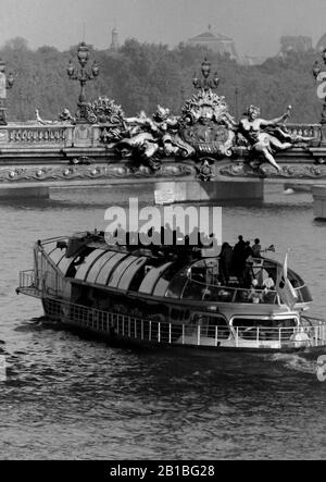 AJAXNETPHOTO. SEPTEMBER 1971. PARIS, FRANKREICH. - UNTER DEN BRÜCKEN VON - EINEM BATEAUX MOUCHE - SEINE-TRIPPER-BOOT - MIT SIGHTSEERS IN SÜDLICHER RICHTUNG UNTER DER ZARENBRÜCKE - VERZIERTE BRÜCKE PONT ALEXANDRE TROIS ÜBER DIE SEINE, BENANNT NACH ZAR ALEXANDER III.FOTO: JONATHAN EASTLAND/AJAX REF:RX7 151204 186 Stockfoto