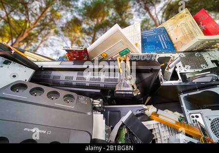 Details zu Elektronikschrott. Hardwarekomponenten des Computers, die unter Bäumen gehaufen sind. Nahaufnahme von gebrauchten PC-Teilen aus Kunststoff oder Metall in der Natur. Umweltfreundlich, CO2-Bilanz. Stockfoto