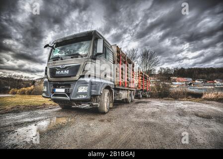 Freyung / DEUTSCHLAND - 23. FEBRUAR 2020: Man TGX 33.640 Holzstapler steht auf einer schmutzigen Straße. Stockfoto