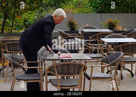 Frau Reinigung Tische im Café vor Service in Paris Frankreich Stockfoto
