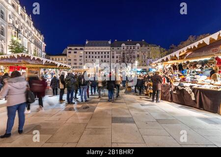 Budapest, Ungarn - 30. November 2019: Menschen auf der Straße am Vorosmarty-Platz mit Weihnachts-Einkaufsmarkt am Abend in der Ferienzeit. Stockfoto