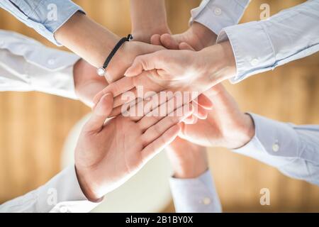 Nahaufnahme, Ansicht von oben Young Business Menschen die Hände zusammen. Stapel von Händen. Einheit und Teamarbeit Konzept. Stockfoto