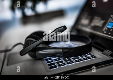 Kommunikation unterstützen, Center und Customer Service Help Desk anrufen. VOIP-Headset auf Laptop Tastatur. Stockfoto