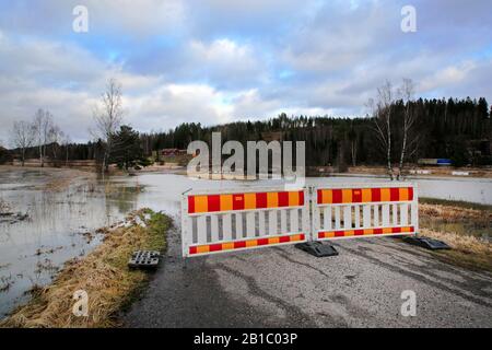 Die kleine Straße abseits der Autobahn 52 ist wegen Flussüberschwemmungen von Perniönjoki im Winter 2020 gesperrt. Perniö, Salo, Finnland, 23. Februar 2020. Stockfoto