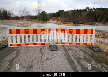 Die kleine Straße abseits der Autobahn 52 ist wegen Flussüberschwemmungen von Perniönjoki im Winter 2020 gesperrt. Perniö, Salo, Finnland, 23. Februar 2020. Stockfoto