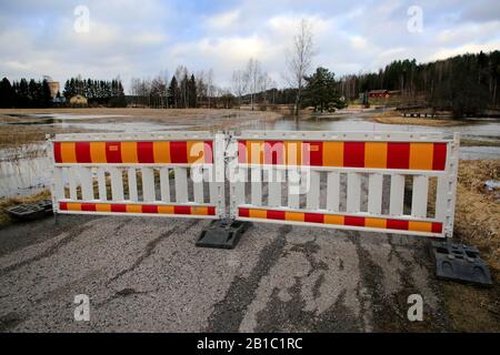 Die kleine Straße abseits der Autobahn 52 ist wegen Flussüberschwemmungen von Perniönjoki im Winter 2020 gesperrt. Perniö, Salo, Finnland, 23. Februar 2020. Stockfoto