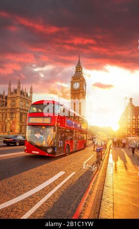 Big Ben mit rotem Bus gegen farbenfrohen Sonnenuntergang in London, England, Großbritannien Stockfoto