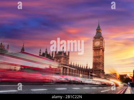 Big Ben mit rotem Bus gegen farbenfrohen Sonnenuntergang in London, England, Großbritannien Stockfoto