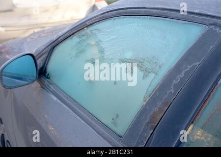Autofenster, die an einem Wintermorgen mit Frost bedeckt sind Stockfoto
