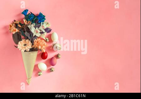 Frühlingsblumen mit ostereiern auf hellrosa Hintergrund. Kopiere Platz für deinen Text und deine Werbeanzeige. Ein Blumenstrauß aus Wildblumen mit gemalten dekorierten osterdekoren Stockfoto