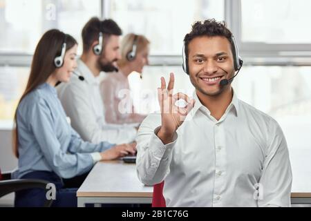 Indischer Callcenter-Agent zeigt eine Geste in Ordnung an. Stockfoto